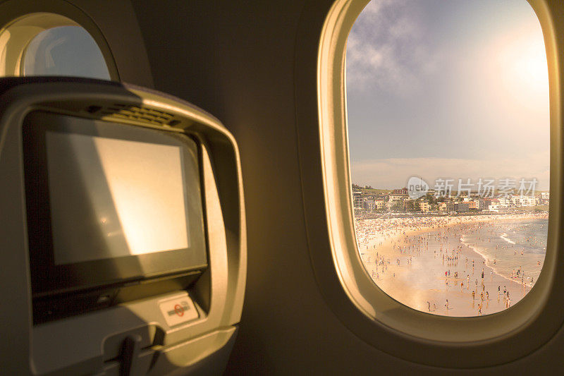 澳大利亚新南威尔士州悉尼市邦迪海滩，飞机从机场起飞后，经济舱座位靠窗俯瞰日落/日出的天空。